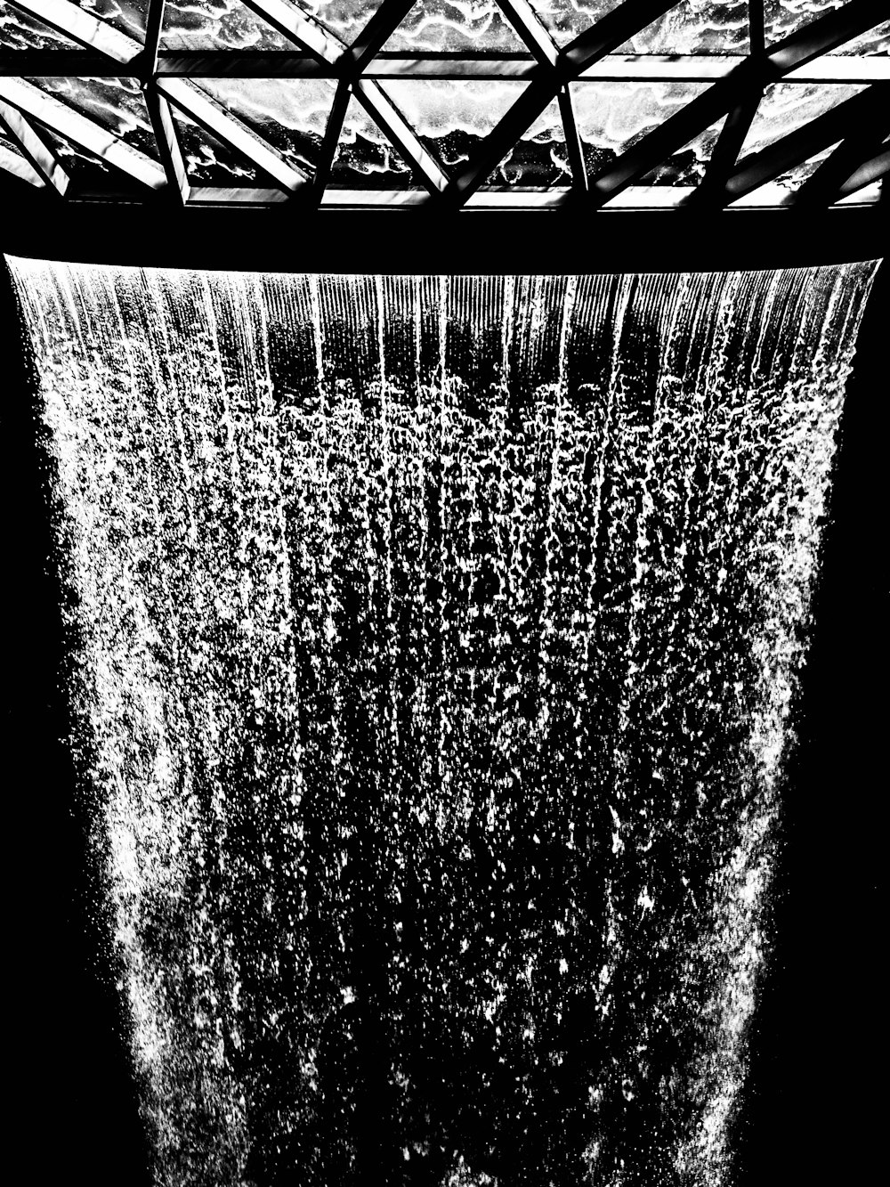 Photo: Sebastian Schuster · Unsplash Ceiling-mounted rain shower head with water falling in low light