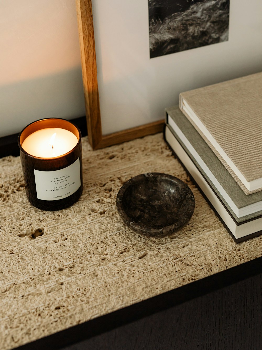 A still life of brass and matte black bathroom objects on a travertine slab