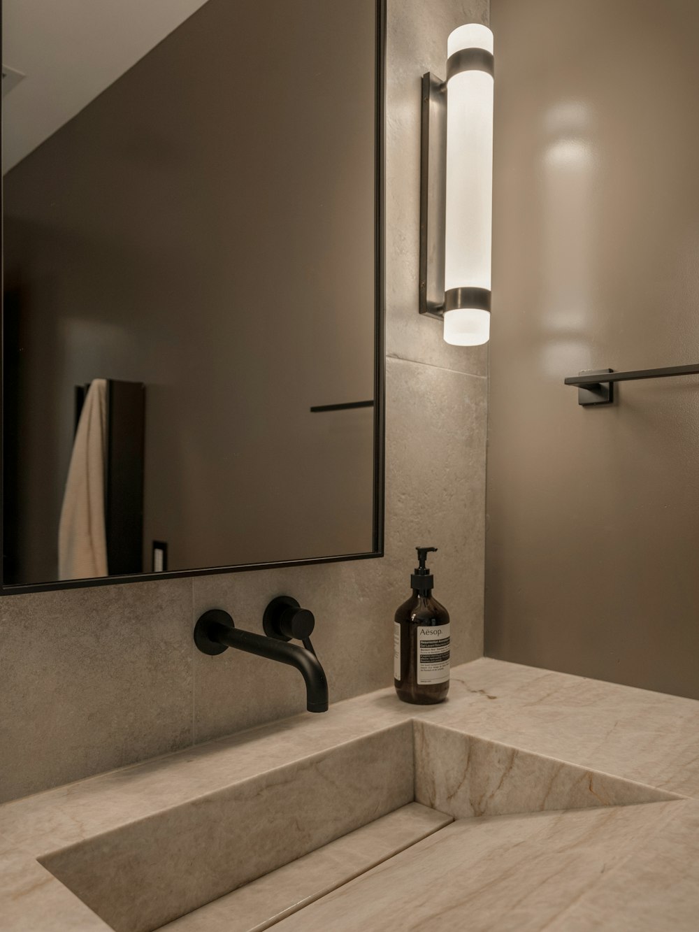 Photo: Peter Muniz · Unsplash Matte black sensor foam dispenser standing on a marble counter